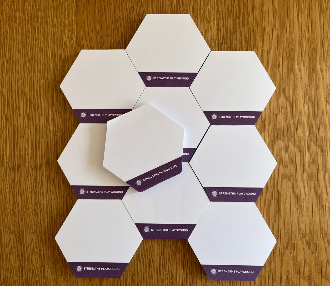 Hexagonal tiles with a brand logo on a wooden surface