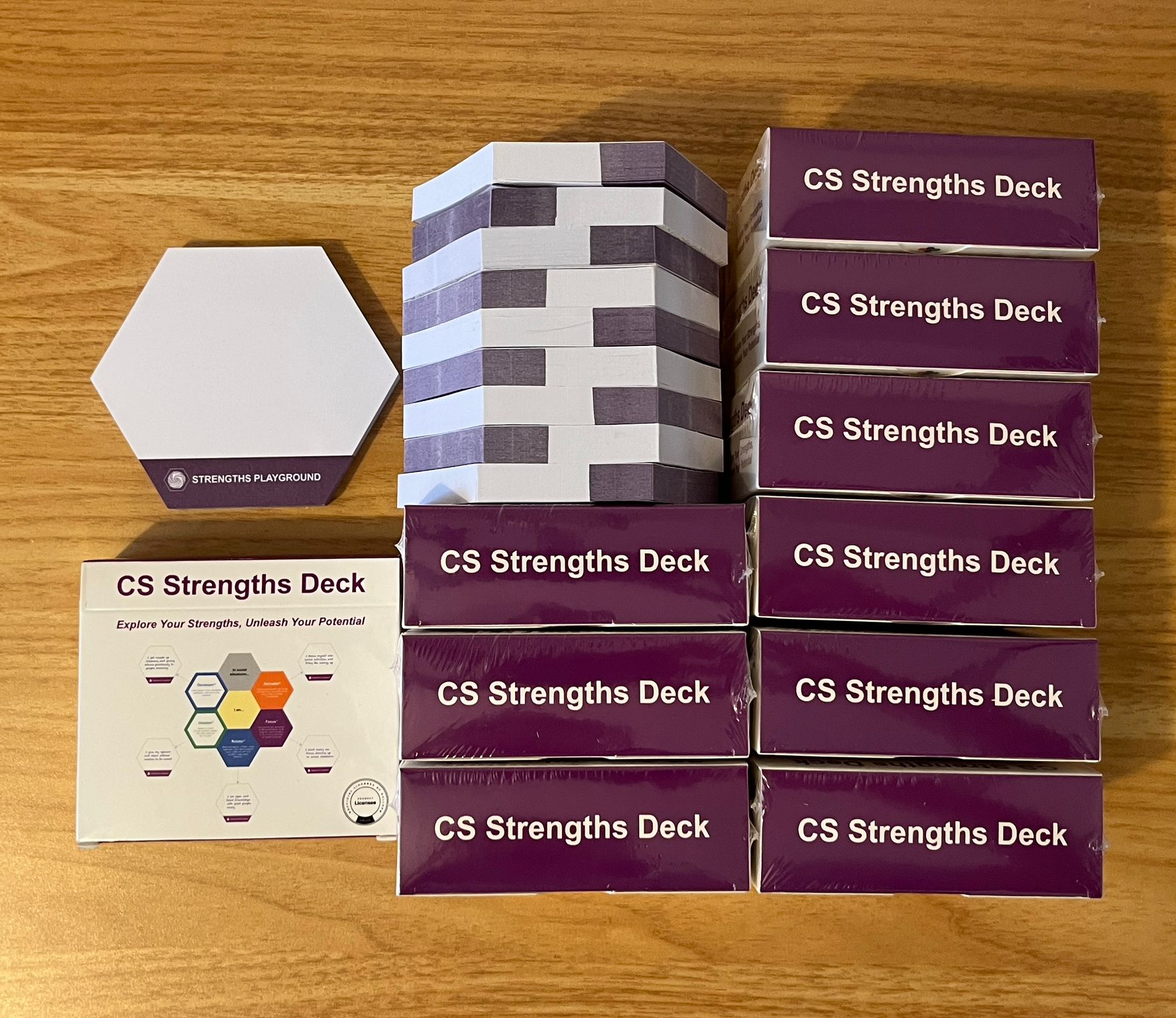 Multiple boxes of 'CS Strengths Deck' on a wooden surface