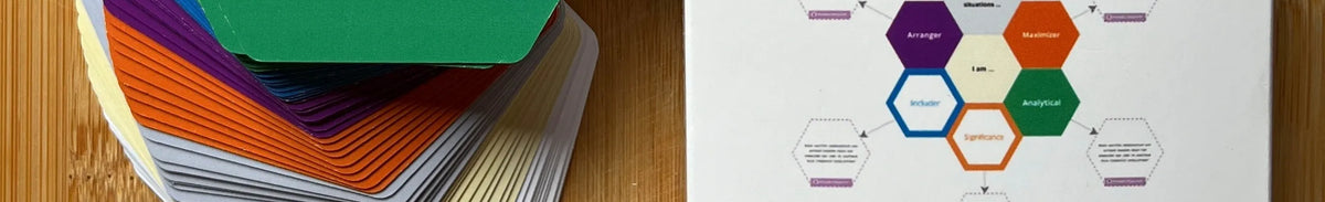 Colorful index cards stacked on a wooden surface with a hexagonal diagram on paper.